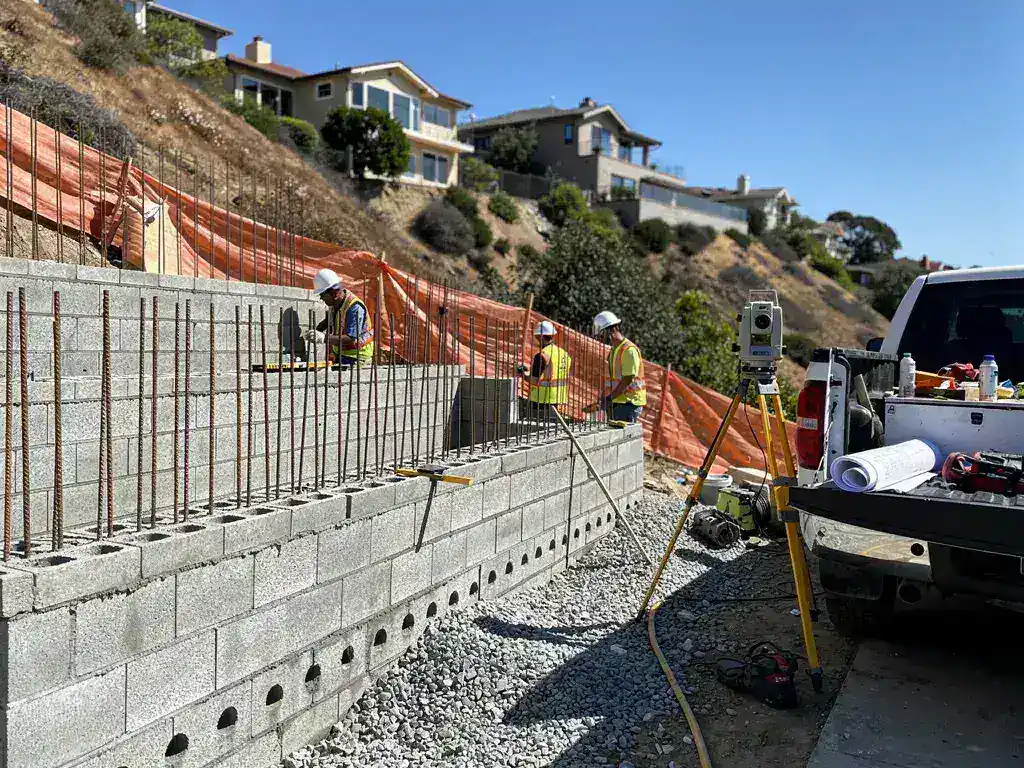 Licensed structural contractors installing a reinforced CMU retaining wall in Topanga Canyon Los Angeles hillside